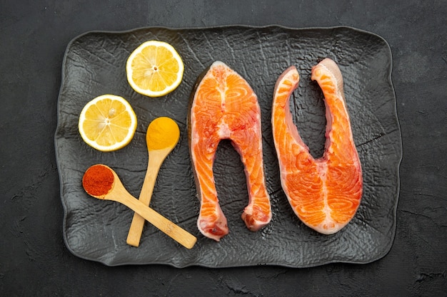 Free photo top view fresh meat slices inside plate with lemon on dark background