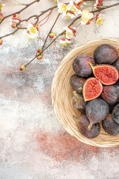 Free Photo top view fresh persimmons in wicker basket apricot blossom branches on nude background