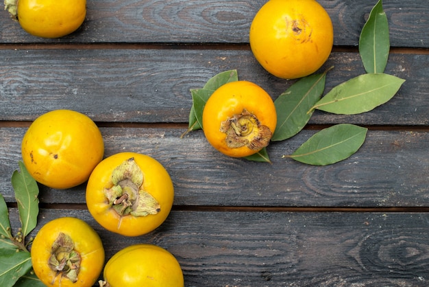 Top view fresh persimmons on a wooden rustic table, fruit ripe mellow