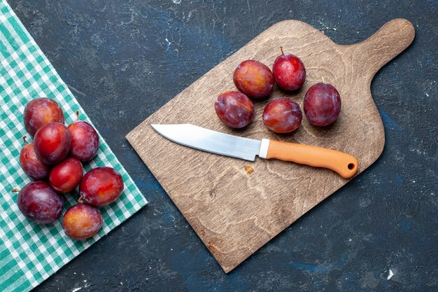 Top view of fresh plums whole mellow and juicy on dark desk, fruit berry fresh