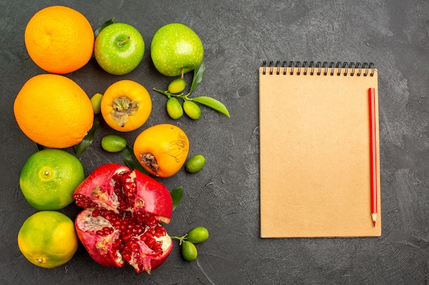 Top view fresh pomegranates with apples and other fruits on a dark surface ripe fruit color