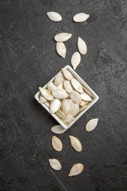 Top view fresh pumpkin seeds on dark background seed granule darkness photo