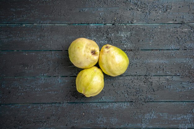 Top view fresh quinces mellow and sour fruits on dark blue desk ripe fetus fresh tree sour plant