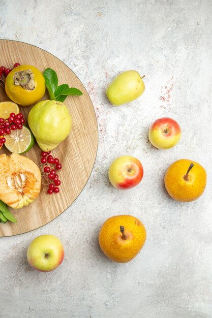 Top view fresh quinces with other fruits on a white table ripe fruit mellow fresh