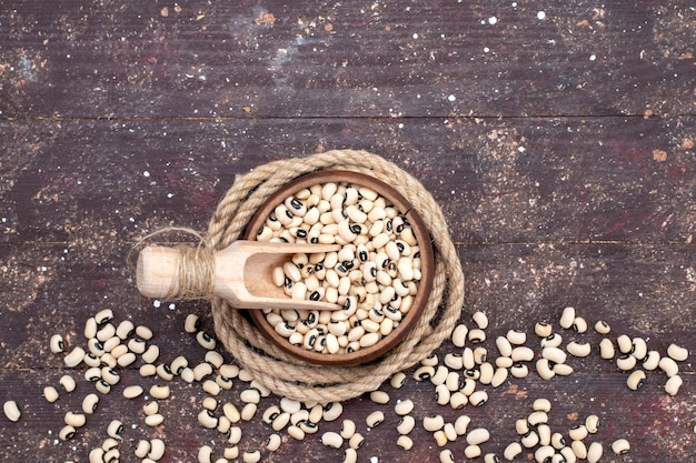 Top view of fresh raw beans inside brown bowl and spread all over the brown, food raw bean haricot