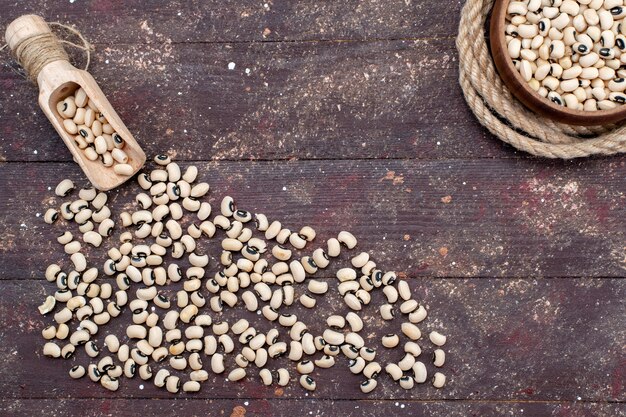 Top view of fresh raw beans spread all over the brown desk, food raw bean haricot