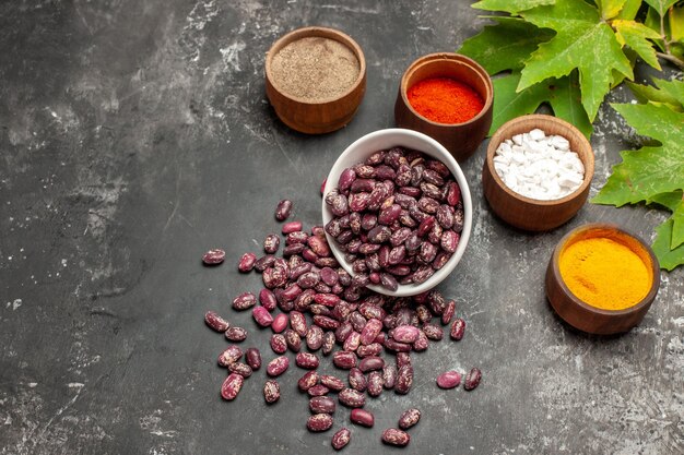 Top view fresh raw beans with seasonings on the grey surface