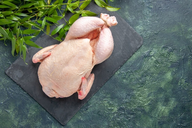 Top view fresh raw chicken with green leaves on dark background chicken meal animal photo food color kitchen meat