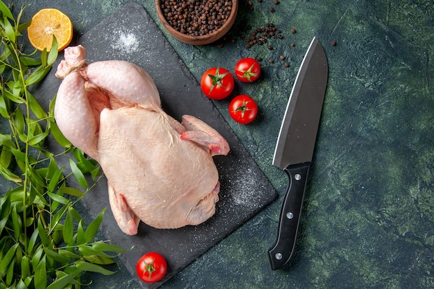 Top view fresh raw chicken with red tomatoes on dark background meal animal photo food color chicken meat