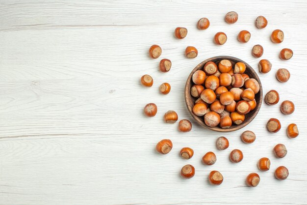 Top view fresh raw hazelnuts on white desk