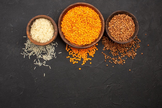 Top view fresh raw lentil with buckwheat on the dark space