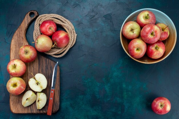 Top view fresh red apples juicy and mellow with brown desk on dark-blue background ripe fruit fresh mellow vitamine