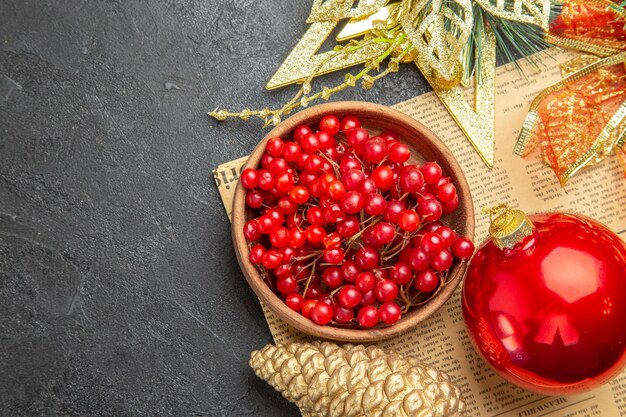 Top view fresh red cranberries with christmas toys on dark background