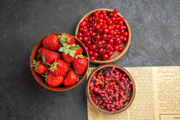 Top view fresh red cranberries with other fruits on dark background