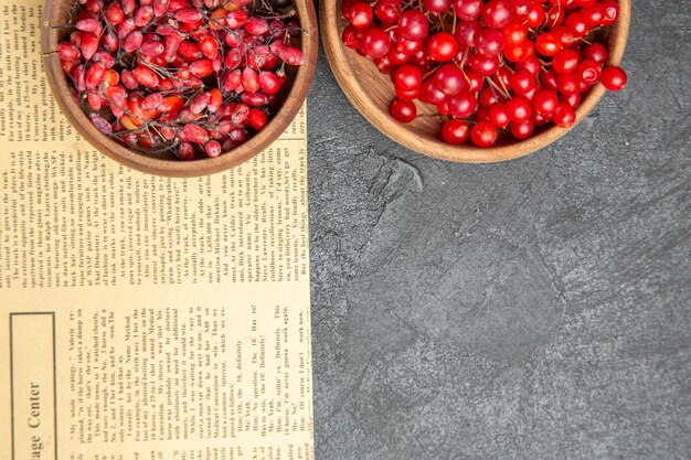 Top view fresh red cranberries with other fruits on dark background