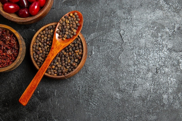 Top view of fresh red dogwoods with seasonings on grey surface