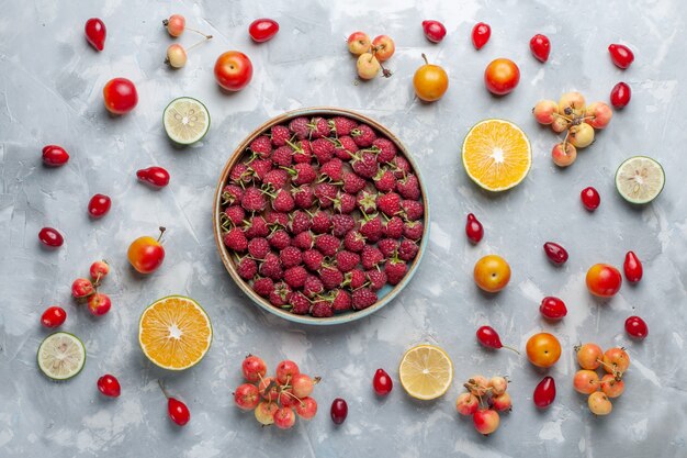 Top view fresh red raspberries with lemon and cherries on white desk fruit berry vitamine summer mellow