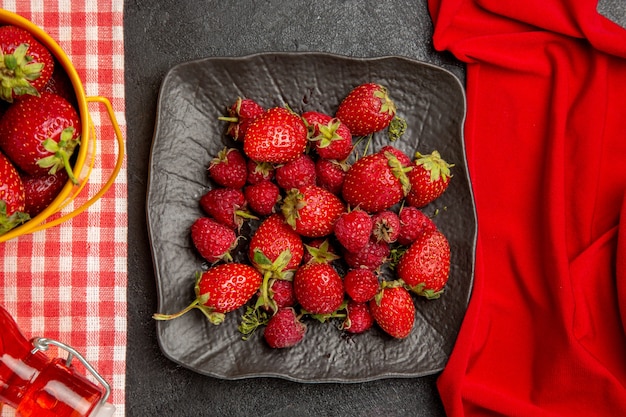 Top view fresh red strawberries on a dark table color fruit raspberry berry