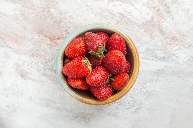 Top view fresh red strawberries inside little plate on white table berry fruit wild