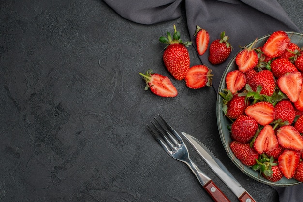 Top view fresh red strawberries inside plate on dark background