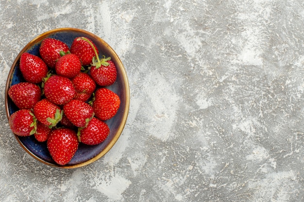 Top view fresh red strawberries inside plate on the white background