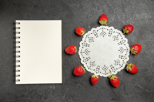 Top view fresh red strawberries lined on a dark table color berry fruit