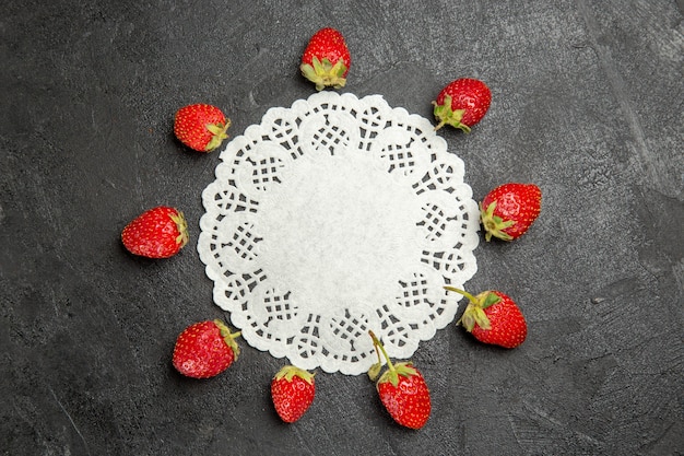 Top view fresh red strawberries lined on dark table color berry fruit