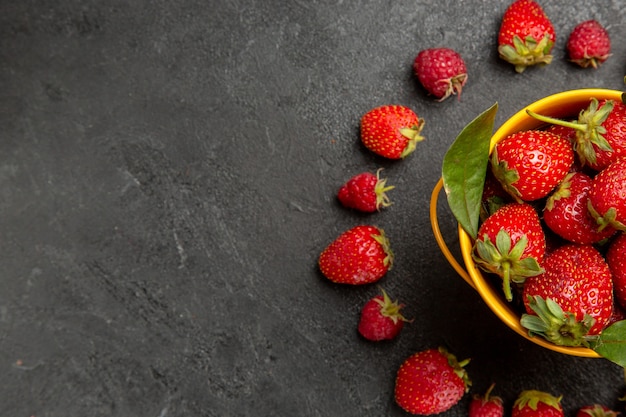 Top view fresh red strawberries lined on dark table colors berry fruit