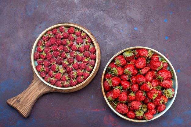 Top view fresh red strawberries mellow fruits with raspberries on dark-blue surface berry fruit mellow summer food