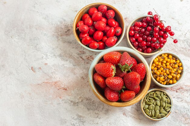 Top view fresh red strawberries with other fruits on white table fruit berry