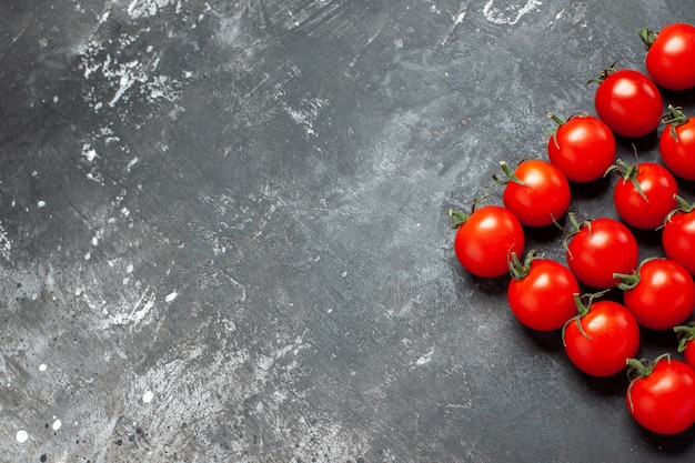 Top view fresh red tomatoes lined on light-dark background