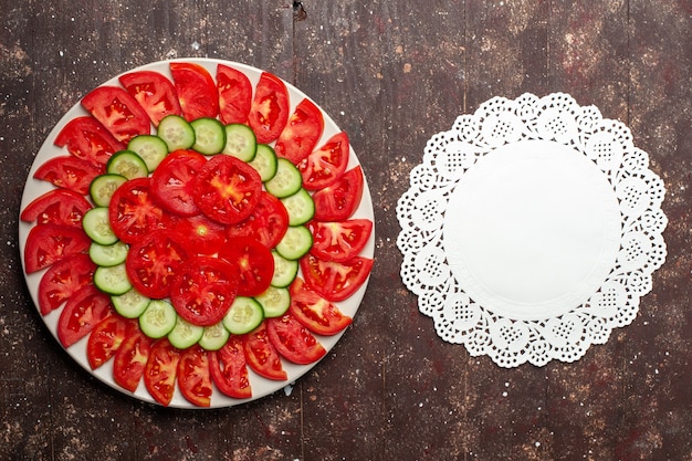 Free photo top view fresh red tomatoes sliced fresh salad on a brown space