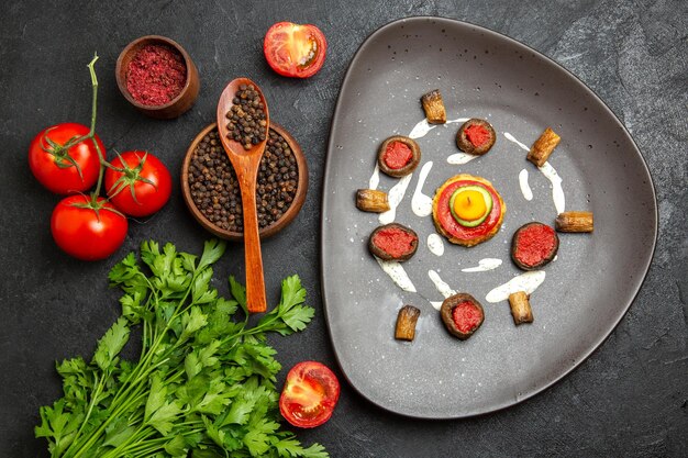 Top view of fresh red tomatoes with greens on grey surface