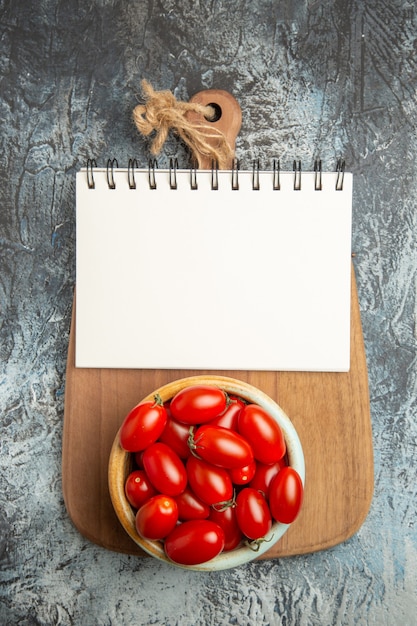 Free photo top view fresh red tomatoes with notepad