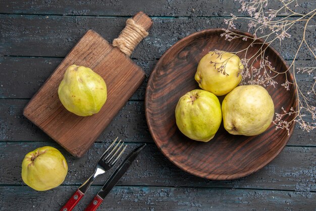 Top view fresh ripe quinces sour fruits inside plate on dark-blue rustic desk fresh plant ripe tree fruit