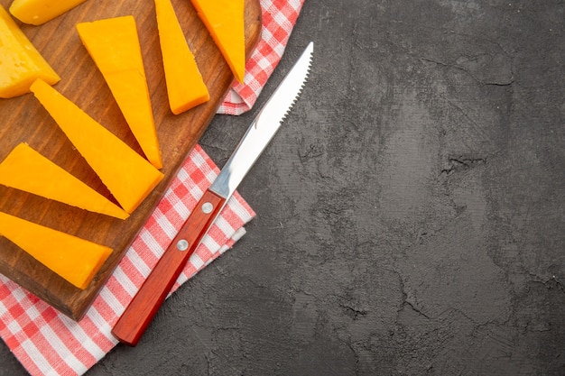 Top view fresh sliced cheese on dark-grey background