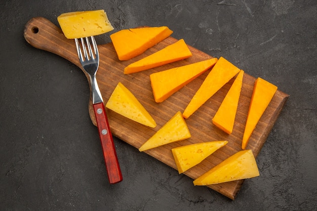 Top view fresh sliced cheese on dark-grey background