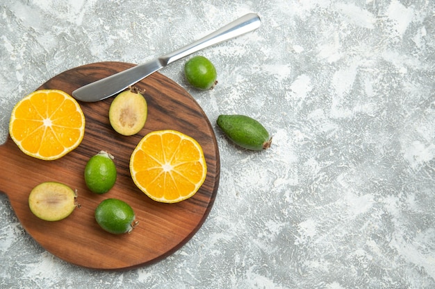 Top view fresh sliced oranges with feijoa on white surface ripe fruits exotic tropical fresh