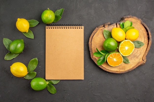 Top view fresh sour lemons on the dark-grey table fruit citrus lime