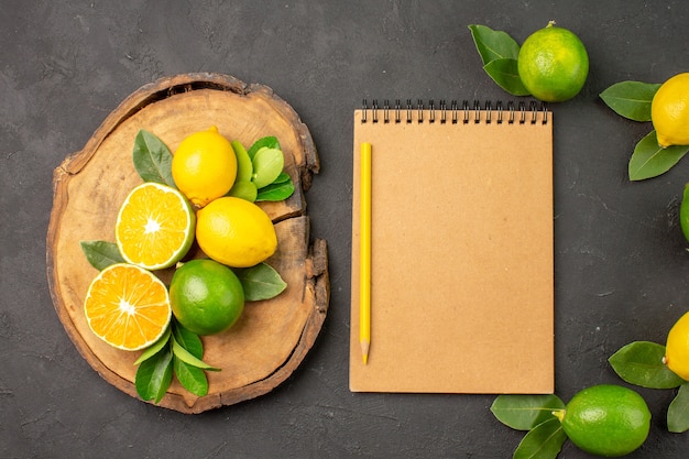 Top view fresh sour lemons on a dark-grey table fruits citrus lime