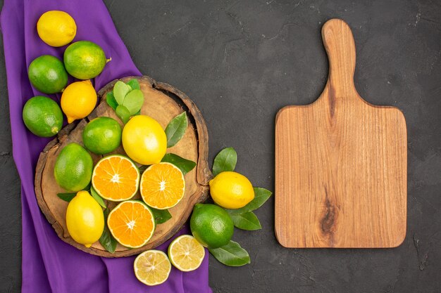 Top view fresh sour lemons on dark table citrus lime fruit