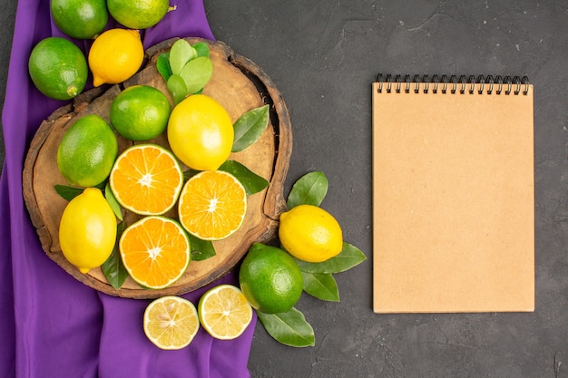 Top view fresh sour lemons on the dark table citrus lime fruit