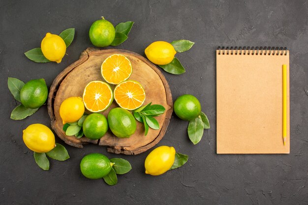 Top view fresh sour lemons on the dark table citrus lime fruit