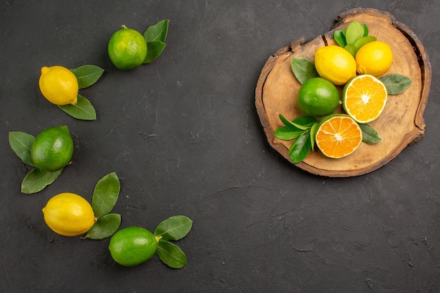 Top view fresh sour lemons on dark table fruit citrus limes