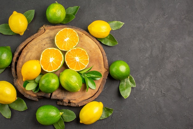 Top view fresh sour lemons on the dark table lime citrus fruit