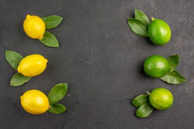 Top view fresh sour lemons on dark table lime fruit citrus mellow ripe