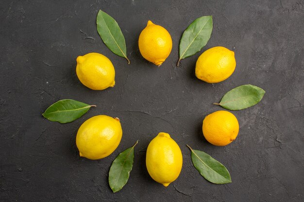 Top view fresh sour lemons lined on dark table fruit citrus yellow lime