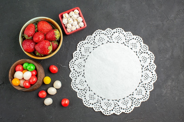 Free photo top view fresh strawberries with candies