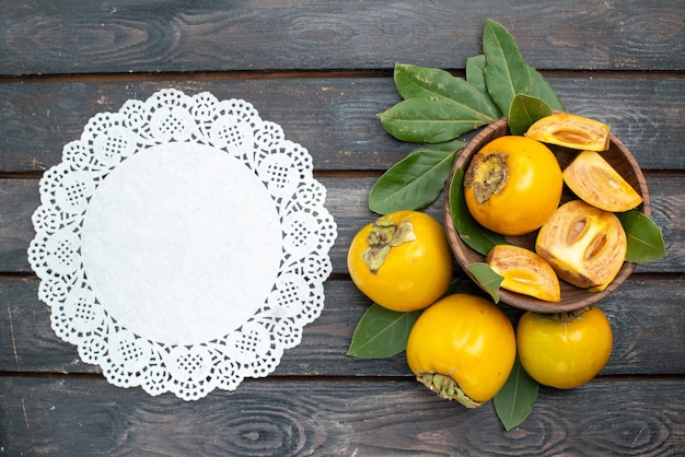 Free Photo top view fresh sweet persimmons on wooden table, fruits ripe mellow