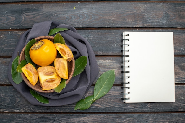 Free photo top view fresh sweet persimmons on the wooden table, mellow fruit health